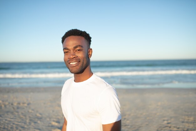 Hombre feliz de pie en la playa