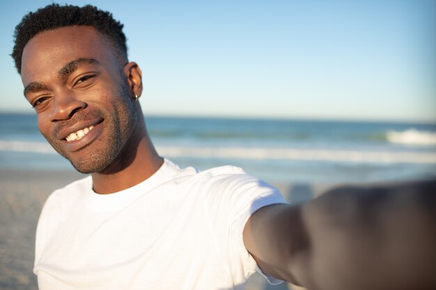 Hombre feliz de pie en la playa