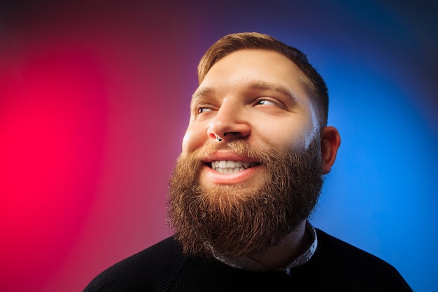 Hombre feliz de pie y sonriendo aislado en estudio rosa