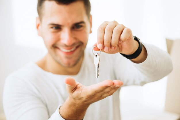 Hombre feliz posando con llaves