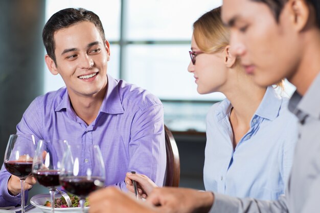 Hombre feliz que habla a hembra Compañero de trabajo durante la cena