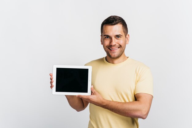 Hombre feliz que sostiene una tableta en maqueta de las manos