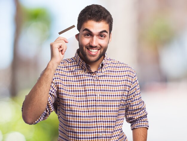 Hombre feliz que sostiene la tarjeta de crédito.