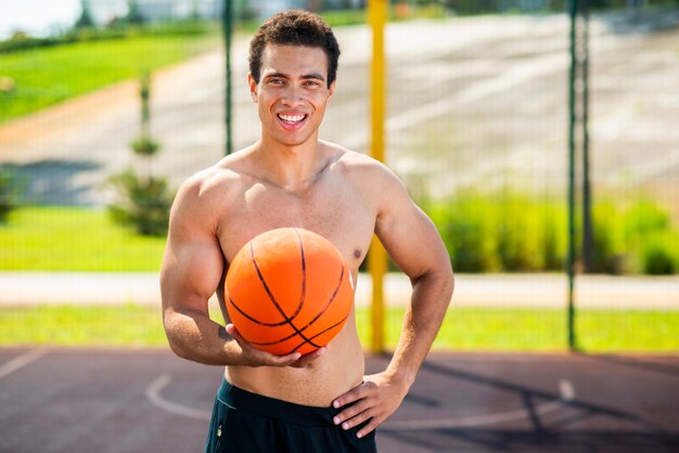 Hombre feliz que sostiene un tiro medio de la bola