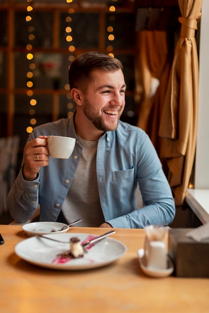 Hombre feliz en el restaurante tomando café