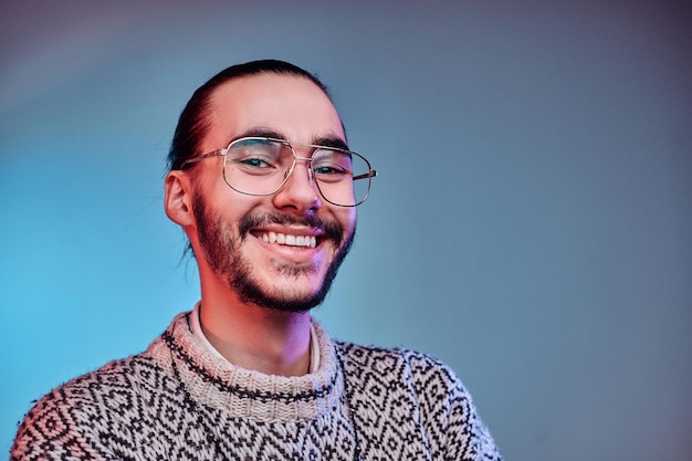 Un hombre feliz y sonriente con suéter de invierno posa para el fotógrafo en el estudio.