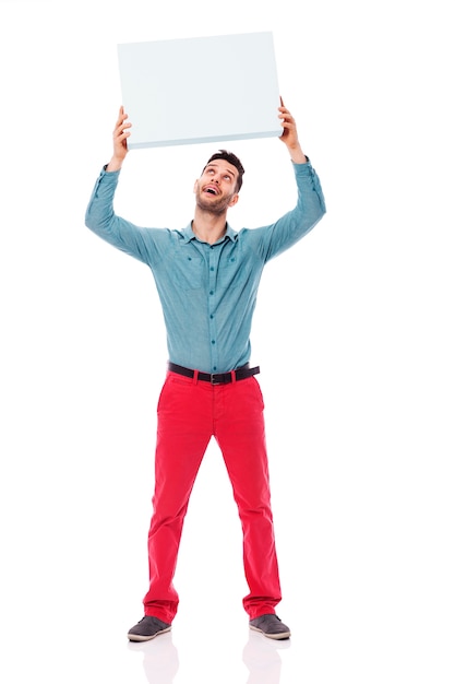 Hombre feliz sosteniendo un cartel en blanco arriba