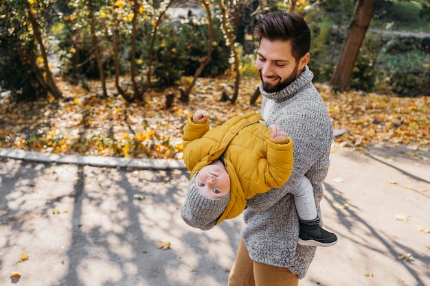 Hombre feliz con su hijo al aire libre