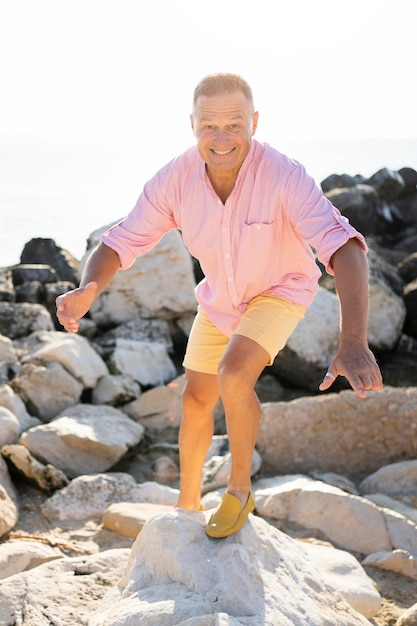 Hombre feliz de tiro completo en las rocas