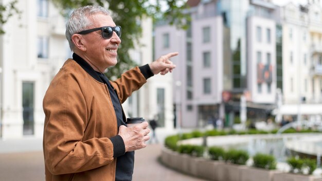 Hombre feliz de tiro medio en la ciudad