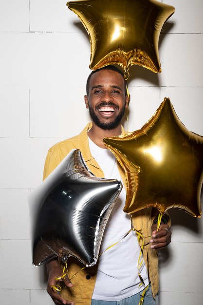 Hombre feliz de tiro medio con globos