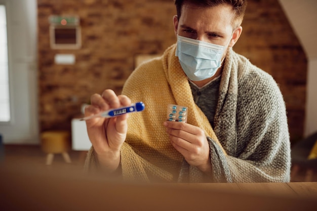 Foto gratuita hombre con fiebre que tiene una videollamada con su médico desde casa debido a la pandemia de covid19