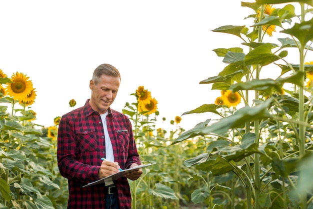 Foto gratuita hombre firmando en un portapapeles en un campo