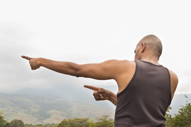 Hombre fitness latino colombiano afroamericano observando montañas