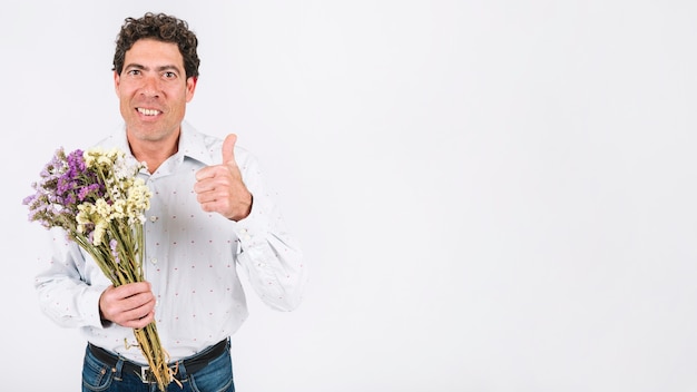 Hombre con flores gesticulando pulgar arriba