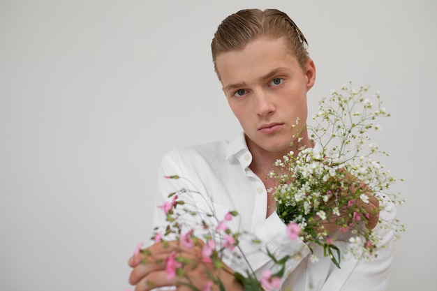 Hombre con flores posando vista frontal