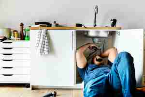 Foto gratuita hombre fontanero fijación fregadero de la cocina