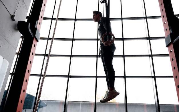 Foto gratuita hombre en forma atractiva trabajando en el interior en el gimnasio