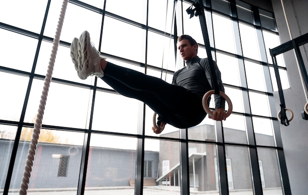 Hombre en forma atractiva trabajando en el interior en el gimnasio