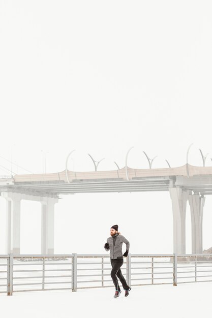 Hombre en forma de disparo completo corriendo al aire libre