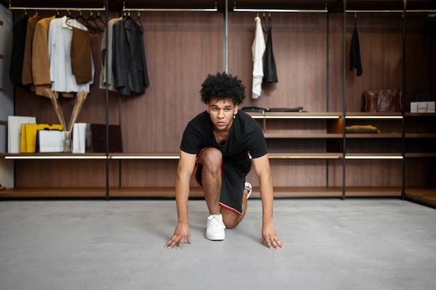 Hombre en forma haciendo burpee en el armario tiro completo