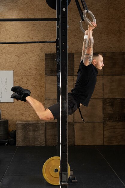 Hombre en forma haciendo ejercicio en el gimnasio tiro completo