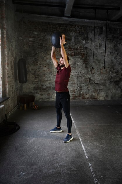 Hombre en forma de tiro completo entrenando con pelota