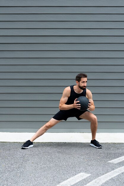 Hombre en forma de tiro completo entrenando con pelota