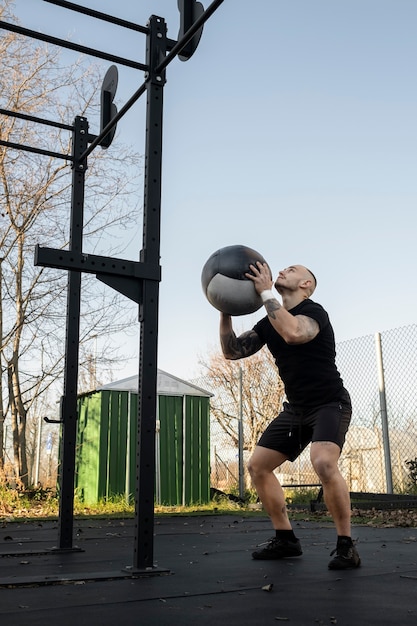 Hombre en forma de tiro completo haciendo ejercicio con pelota