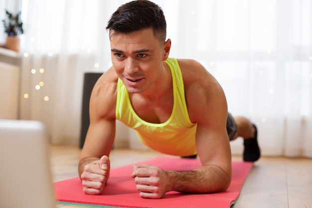 Foto gratuita hombre en forma de tiro completo haciendo tablón