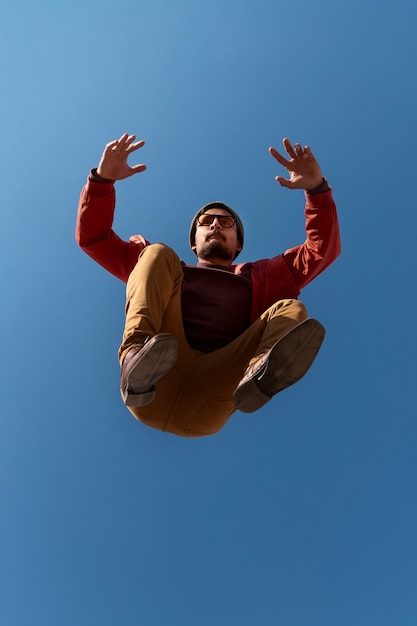 Foto gratuita hombre en forma de tiro completo saltando al aire libre