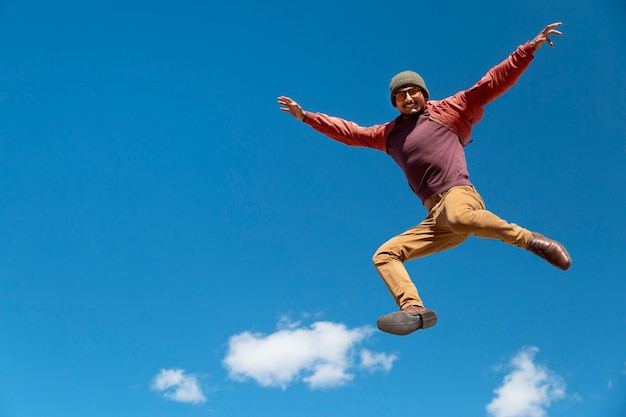 Foto gratuita hombre en forma de tiro completo saltando al aire libre