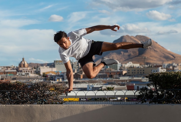 Foto gratuita hombre en forma de tiro completo saltando al aire libre