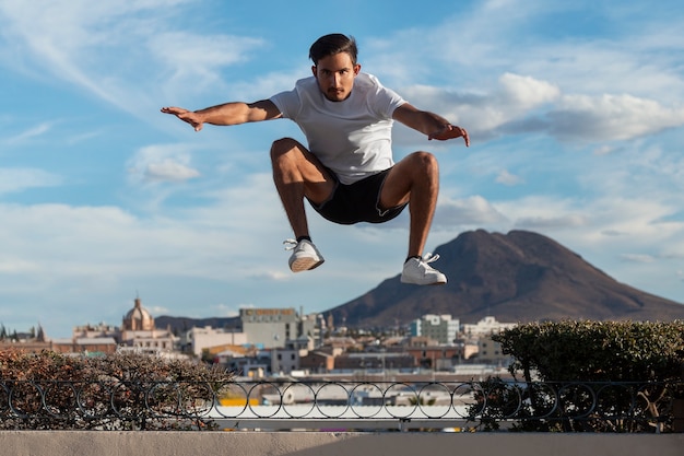 Foto gratuita hombre en forma de tiro completo saltando al aire libre