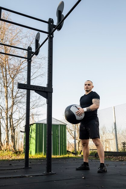 Hombre en forma de tiro completo sosteniendo la pelota