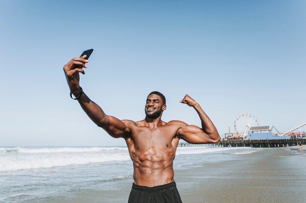 Hombre en forma tomando un selfie por el muelle de Santa Mónica