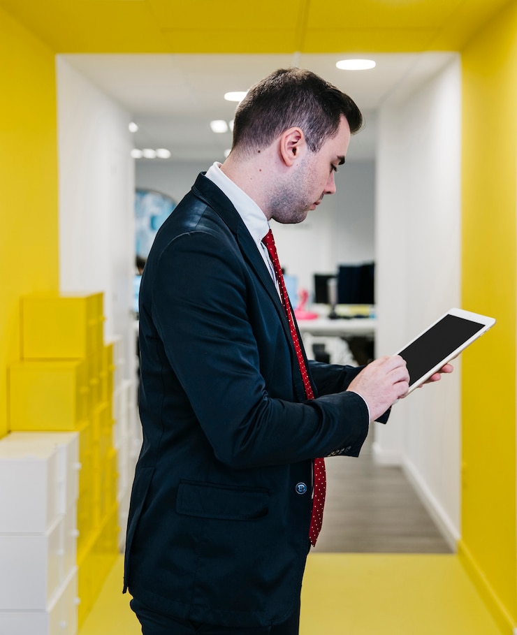 Foto gratuito hombre formal que usa la tableta en oficina