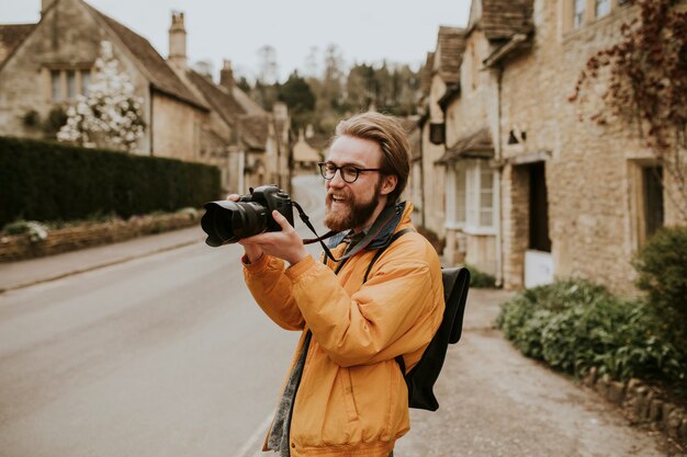 Hombre fotógrafo tomando fotos en la aldea de Cotswolds, REINO UNIDO