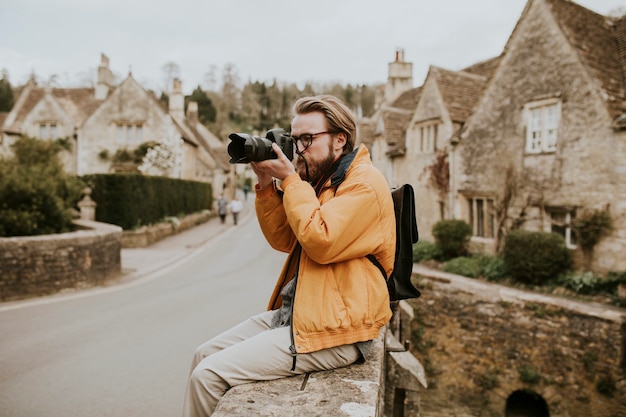 Foto gratuita hombre fotógrafo tomando fotos en la aldea de cotswolds, reino unido