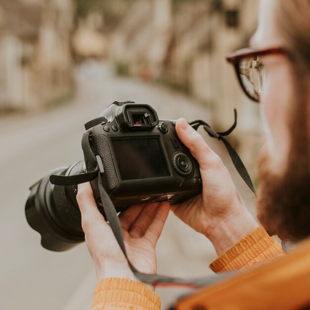 Hombre fotógrafo viendo sus fotos en la cámara