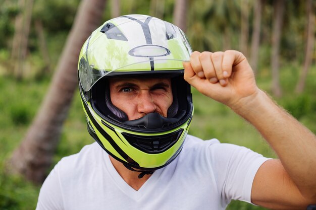 Hombre fuerte en el campo de la selva tropical con moto roja