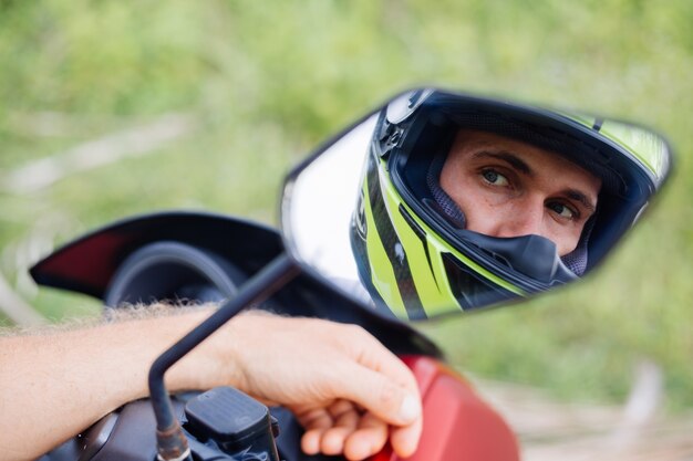 Hombre fuerte en el campo de la selva tropical con moto roja