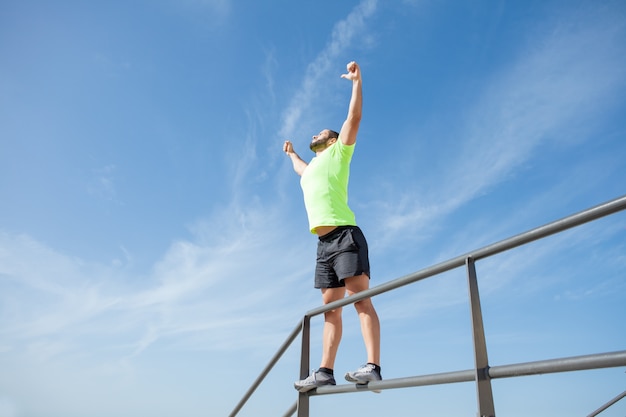 Hombre fuerte celebrando el éxito del deporte al aire libre