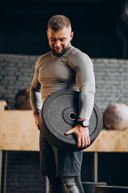 Hombre fuerte guapo haciendo ejercicio en el gimnasio