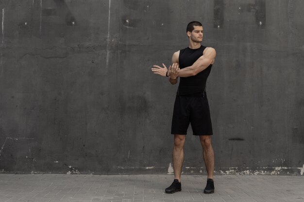 Hombre fuerte, musculoso y deportivo calentando, preparándose para entrenar