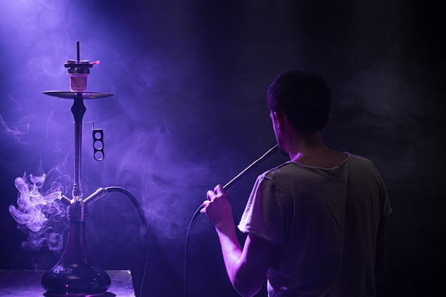 Foto gratuita el hombre fumando la clásica shisha