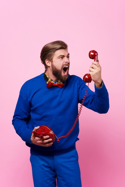 Hombre furioso discutiendo mientras llamada telefónica