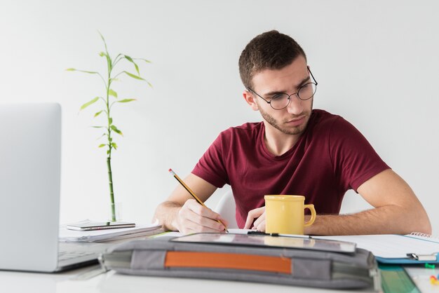 Hombre con gafas enfocado blanco leyendo un periódico