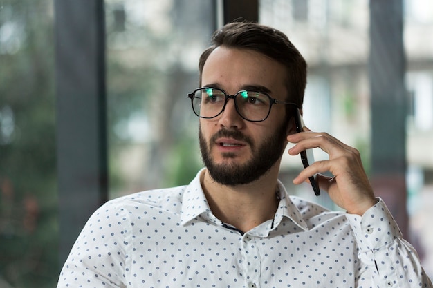 Foto gratuita hombre con gafas hablando por teléfono