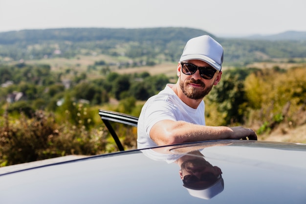 Foto gratuita hombre con gafas saliendo del coche